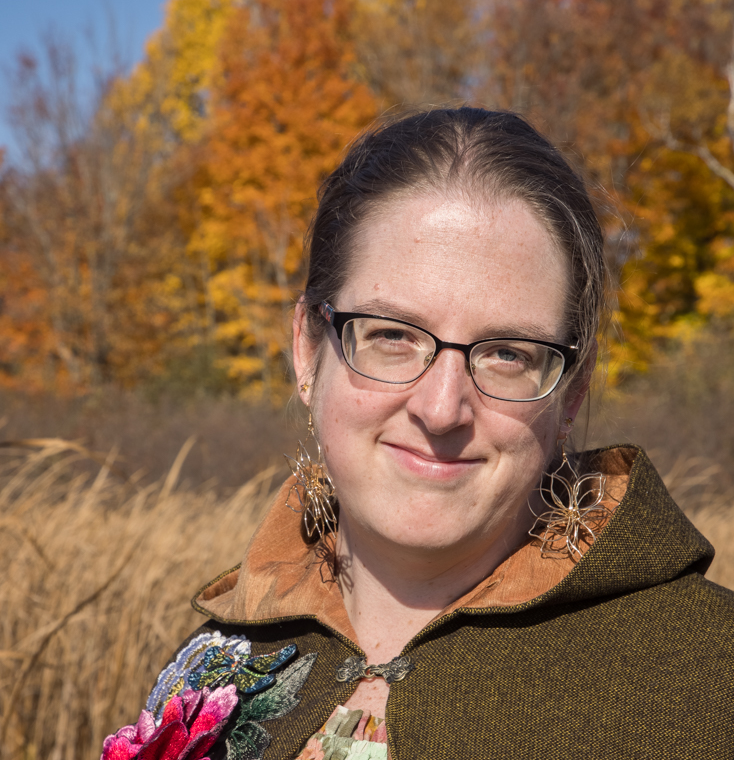 Caleigh Jerry, Twillow Lifestyle team member, standing outdoors in a natural autumn setting.